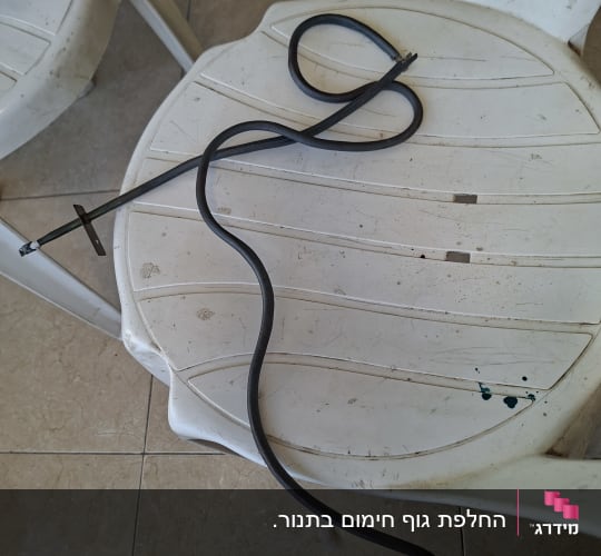 כבל חשמלי מונח על כיסא פלסטיק לבן